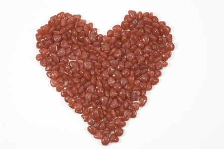 red candy in heart shape isolated on white backgroundの写真素材