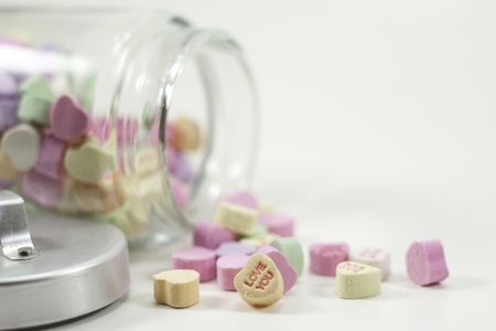a jar of valentine hearts spilled isolated on white backgroundの写真素材
