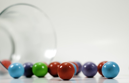 spilled colorful gumballs with a glass jar isolated on white backgroundの写真素材