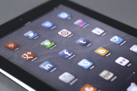 a black tablet with social media icons and a shallow depth of fieldのeditorial素材