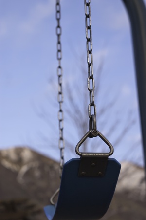 empty blue swing sitting still at a parkの写真素材