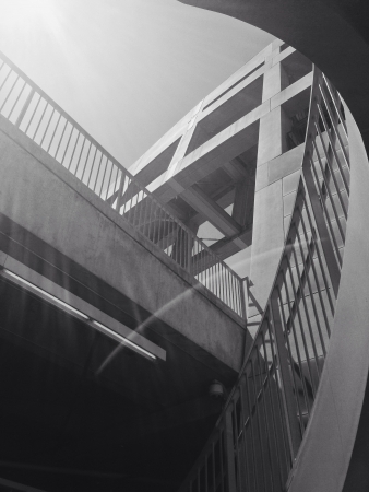 Stairs and walkways around concrete structure with bright overhead light. の素材
