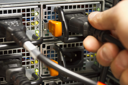 Technician   engineer inserts power cord into a rack server in the second power supply for...