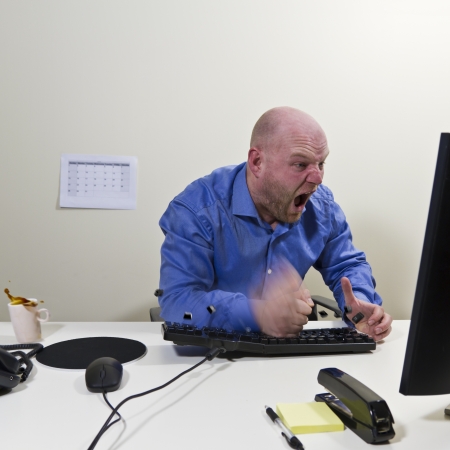 Angry office worker   businessman hit his computer keyboard  Keys and coffee in motion の写真素材
