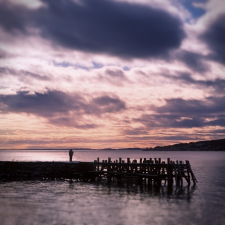 A man fishing at a dock in a sunset  Tilt shift の写真素材