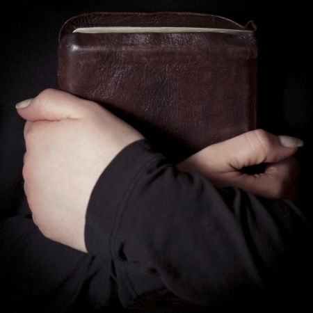 A close-up of a christian woman pray  Holding a Cross over a bible  Toned の写真素材