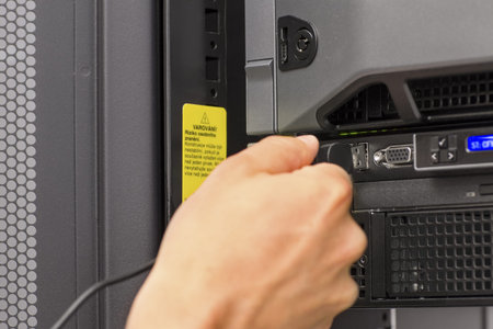 It engineer   consultant working in a data center  Plugs in a usb cable 