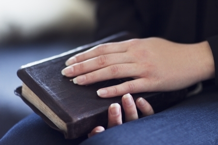A close-up of a christian woman holding   reading the bible  Very shallow depth of fields  Toned の写真素材