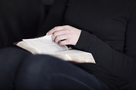 A close-up of a christian woman reading and study in the bible  Very shallow depth of fields  Toned 