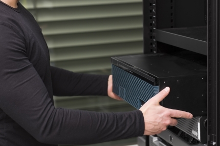 It engineer   consultant install   inserts a router   switch in a rack  Shot in a data center の写真素材