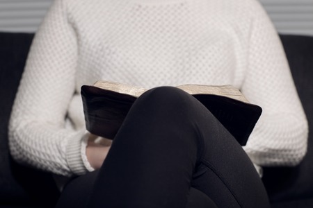 Close-up of a christian woman reading the holy bible  Sitting in sofa の写真素材