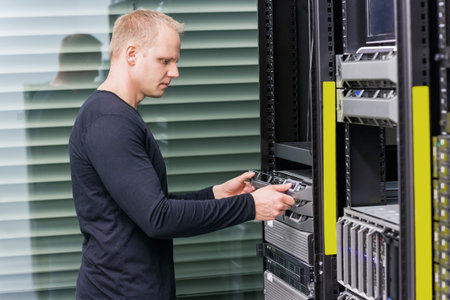 It engineer or consultant installing rack server. Shot in data center.