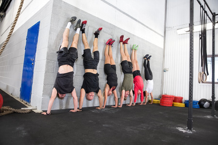 Group does handstand in a workout session at fitness center.の写真素材