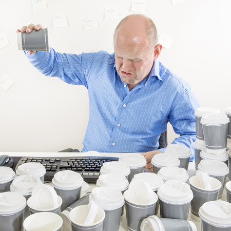 No more coffee for exhausted businessmanの写真素材