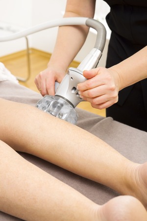 Client receive vacuum massage therapy at legs at professional beauty clinic.の写真素材