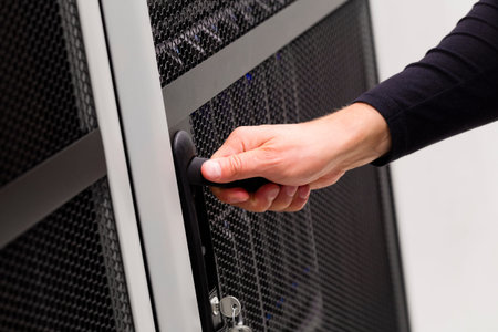 It engineer or consultant opens door to a server rack in data rack. Shot in enterprise datacenter.