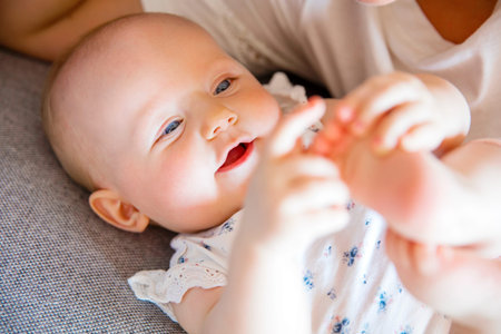 Smiling cute baby girl playing with her caring mother