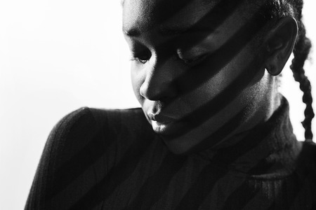 Creative stripes from projection light on beautiful woman with dark skinの写真素材