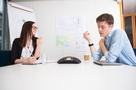 Young Business People Using Conference Phone At Deskの写真素材