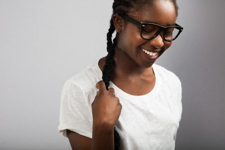 Woman With Braided Hair Wearing Eyeglasses Over Gray Backgroundの写真素材