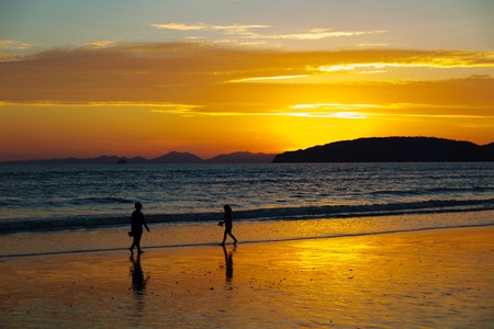 Children Walking At Beach During Sunsetの写真素材