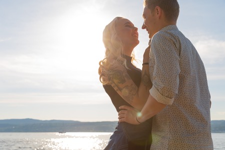 Smiling couple in romantic embrace on beach at summerの写真素材