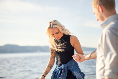 Couple in love holding hands and walking at the beachの写真素材