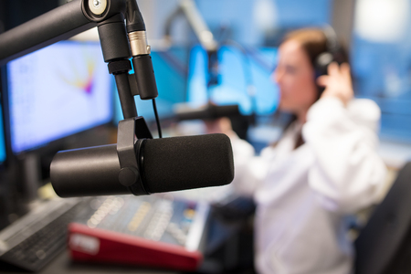 Studio Microphone in Radio Station with Female Host In Backgroundの写真素材