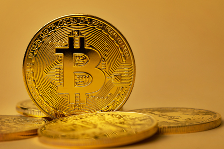 Closeup of shiny gold bitcoin on yellow backgoundの写真素材