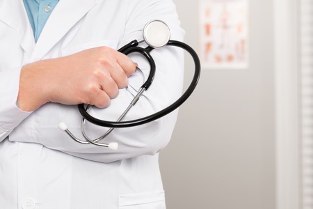 Close-up of a male doctor holding stethoscope in the officeの写真素材