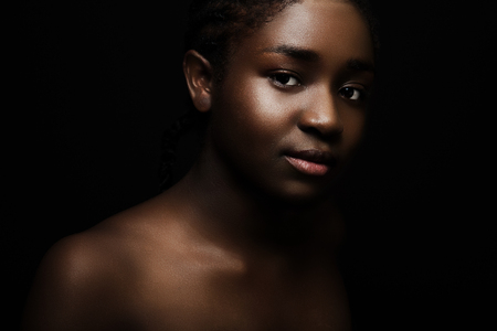 Natural dark bronze portrait of beautiful african woman on black bakgroundの写真素材