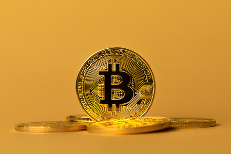 Closeup of gold bitcoins on yellow backgoundの写真素材
