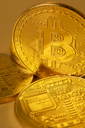 Closeup of gold bitcoin on yellow backgoundの写真素材