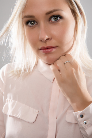 Beautiful female blonde model in shirt holding her hairの写真素材