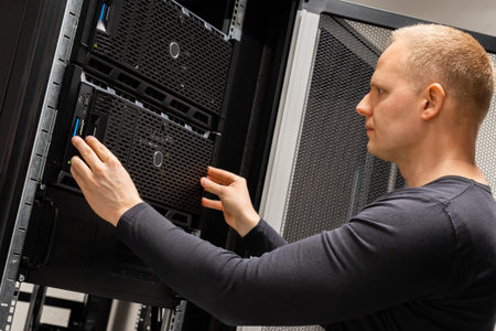 Male Technician Installing Servers In Enterprise Datacenter for Cloud Hosting