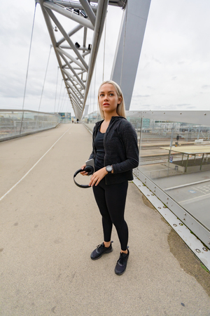 Beautiful Fitness Woman Runner Standing on Modern Bridge In Cityの写真素材
