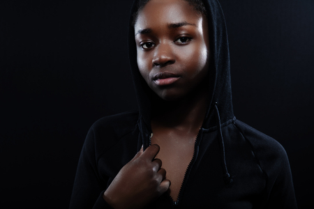 Natural woman with dark skin and attitude wearing black hoodieの写真素材