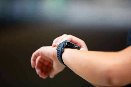 Female hands using fitness smart watch device after runningの写真素材