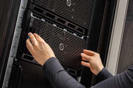 Close-up of Hands Of IT Consultant Installing Servers In Rack at Datacenterの写真素材