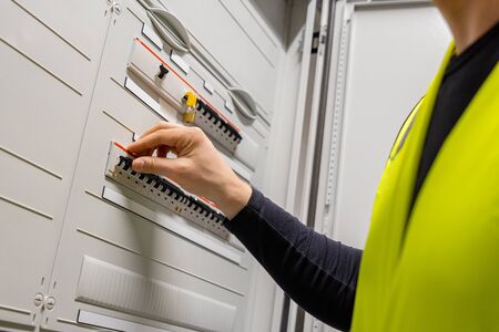 Male Technician Checking Electric Fuse Board In Server Roomの写真素材