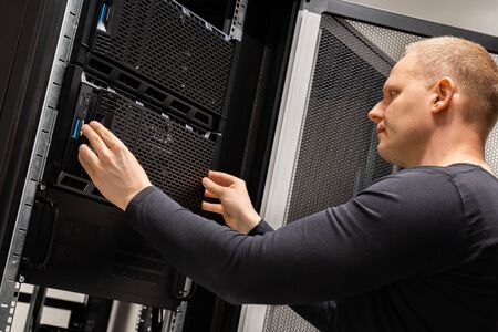 Focused Male Technician Working With Servers In Datacenterの写真素材