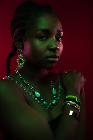 Colorful and creative portrait of beautiful dark african woman on red backgroundの写真素材