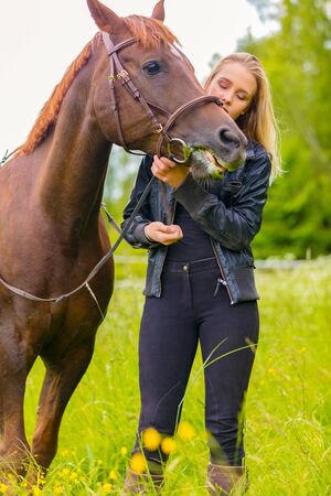 Woman communicate with her beautilful arabian horse friend in the fieldの写真素材