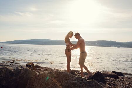 Couple in love holding hands and walking at the beachの写真素材