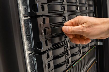 Male IT Engineer Replacing Server Drive in SAN At Datacenterの写真素材