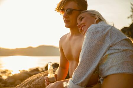Happy Woman Sitting With Boyfriend At Beachの写真素材