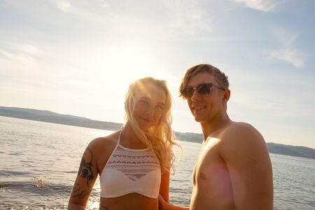 Portrait Of Beautiful Smiling Young Man And Woman At Beachの写真素材