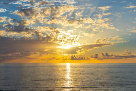 Beautiful sunset over endless sea with reflection in the waterの写真素材