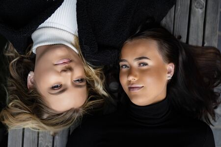 Closeup Portrait Of Close Friends Lying On Bench Together in Cityの写真素材