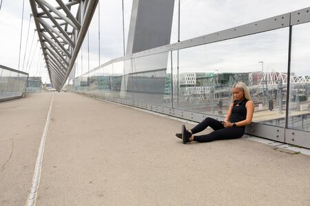 Runner Resting On Bridge After Workout and Check Wokout Performanceの写真素材